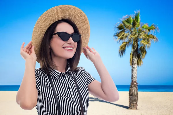 夏天和旅行的概念 戴着太阳镜和草帽在海滩散步的年轻漂亮的女人 — 图库照片