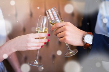 Yeni yıl kutlaması ya da flört konsepti. Şampanya kadehlerini kadın ve erkeğin ellerinde kapat.