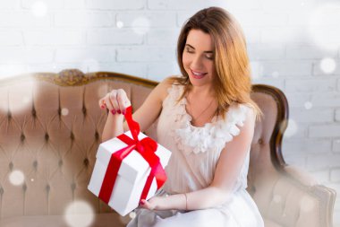 Kış tatili konsepti. Şaşırtıcı genç bir kadın hediye kutusunu açıyor.