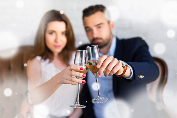 new year celebration - happy beautiful couple with glasses of champagne at restaurant