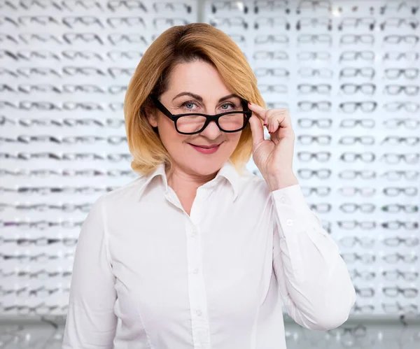 视力和视觉概念 在眼镜店试戴新眼镜的微笑的成熟女人的肖像 — 图库照片