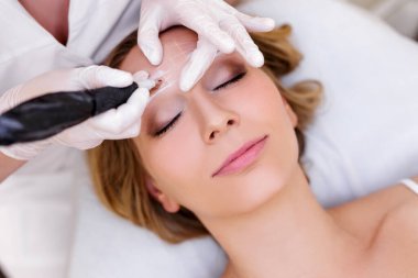 Makyaj ve güzellik konsepti. Güzellik uzmanının kaşlarına kalıcı makyaj uygulaması.