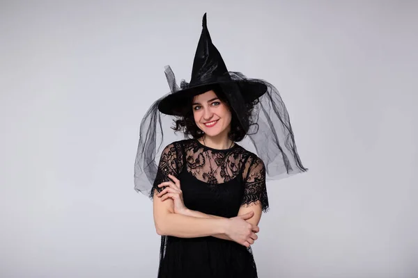 ハロウィンのコンセプト 黒魔女ハロウィンの衣装で笑顔の女性の肖像画とコピースペースと白い背景の上の帽子 — ストック写真