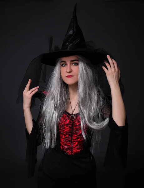 黒魔女ハロウィンの衣装を着た謎の女性の肖像と黒の背景にポーズをとる帽子 — ストック写真