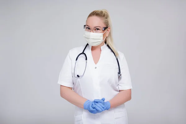 Portret Van Vrouwelijke Arts Chirurgische Masker Bril Handschoenen Poseren Grijze — Stockfoto