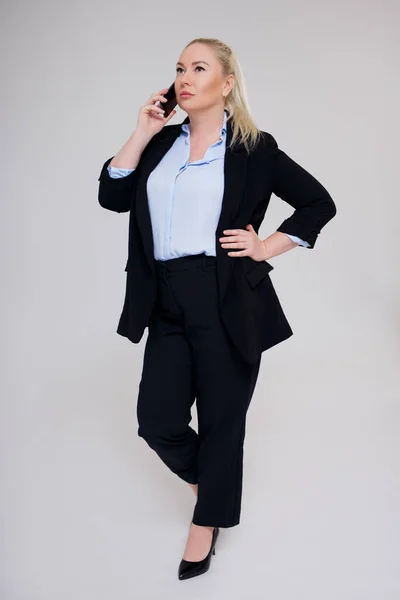 携帯電話で話す美しいプラスサイズビジネス女性の完全な長さの肖像画グレーの背景 — ストック写真