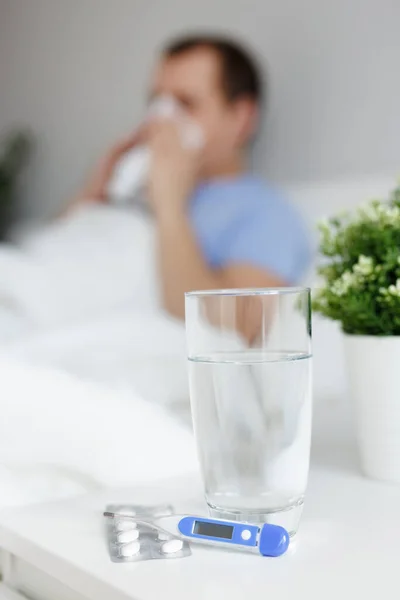 医疗与疾病概念 病人躺在床上 一杯水 药片和温度计放在床头柜上 — 图库照片
