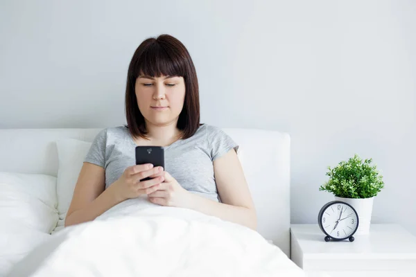 Jovem Mulher Usando Telefone Inteligente Deitado Cama Casa Hotel — Fotografia de Stock