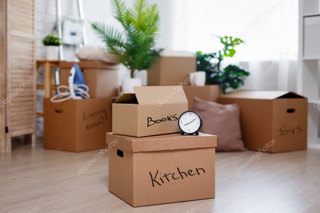 moving day concept - cardboard boxes with belongings prepared for moving into new house