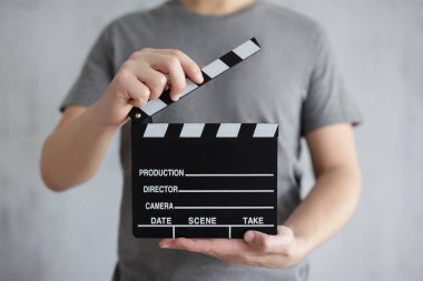 Video ve film yapma konsepti - erkeklerin gri ellerindeki alkışlama tahtası
