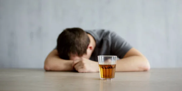 Alcoholism Concept Drunk Man Lying Table Glass Whiskey Gray Wall — Stock Photo, Image