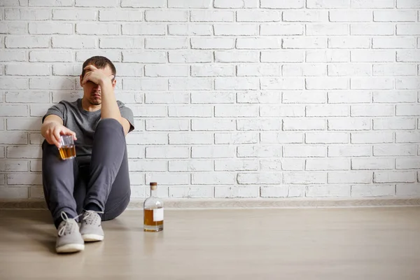 Alcoholism Concept Sad Man Bottle Glass Whiskey Sitting Floor White — Stock Photo, Image