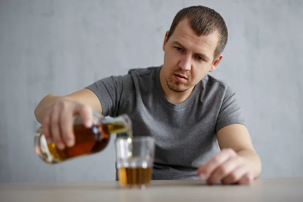 Portret Człowieka Wlewającego Alkohol Szkła Szarym Tle — Zdjęcie stockowe