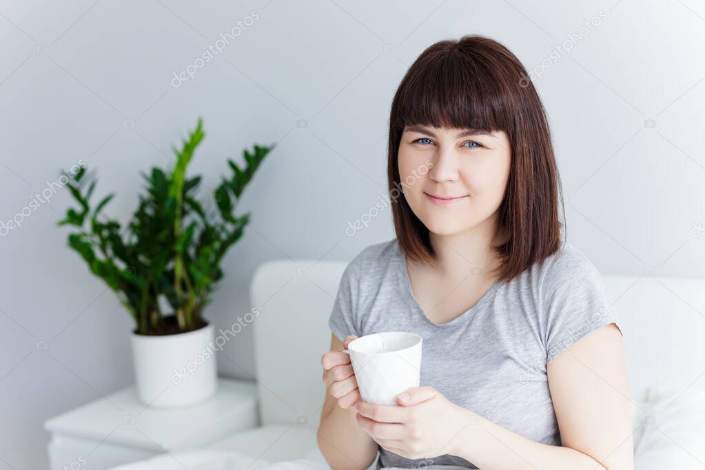 good morning concept - portrait of happy woman drinking coffee at home