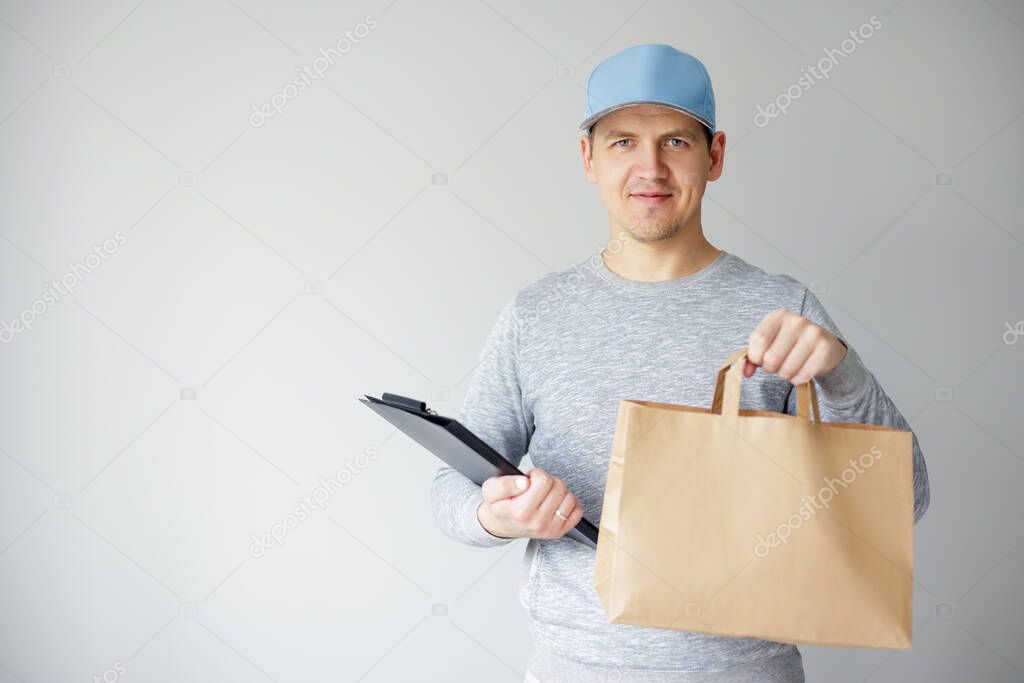 food delivery concept - young delivery man holding paper bag and clipboard over white background with copy space