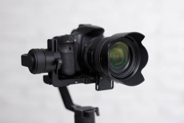 Fotoğraf ya da görüntü seti - Gri arkaplan üzerinde üç eksenli titreşim dengeleyicisi üzerinde modern dslr kameranın kapat