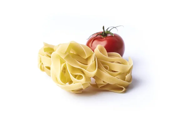 Raw fettuccini and tomatoe — Stock Photo, Image