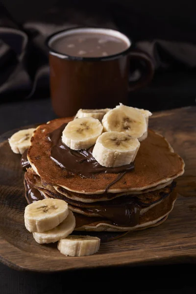 Pannenkoeken en banaan op houten plaat — Stockfoto