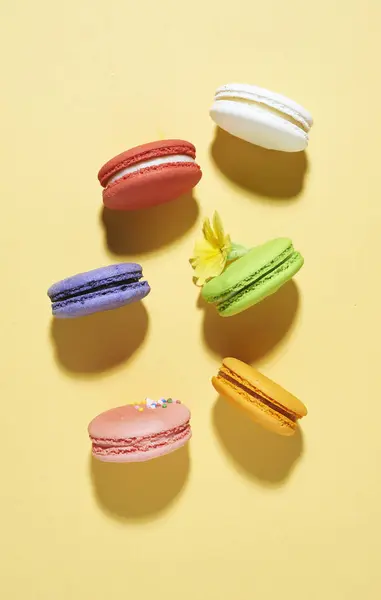 Macaroons multicores em backgroun amarelo — Fotografia de Stock