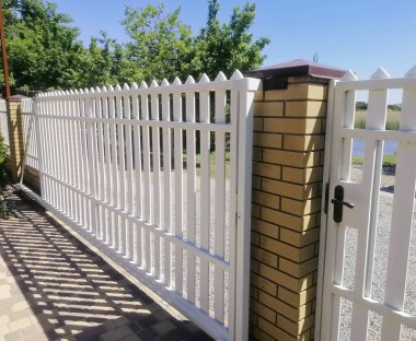 El değmemiş beyaz çitler modern hatlarla özel sınırlar çiziyor. Pürüzsüz paneller görsellik olmadan zarif bariyerler oluşturur. Çağdaş beyaz eskrim güvenliği sağlar. 