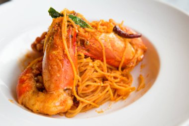 Spagetti Tom Yam Goong dev nehir karides beyaz disk ile.