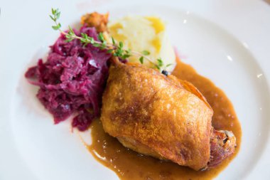 Mor lahana ve patates püresi beyaz tabakta ördek confit