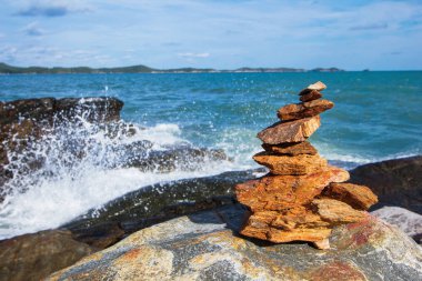 Deniz plaj taş yığını istikrarlı ve dalga sıçrama soyut ve mavi gökyüzü arka plan 