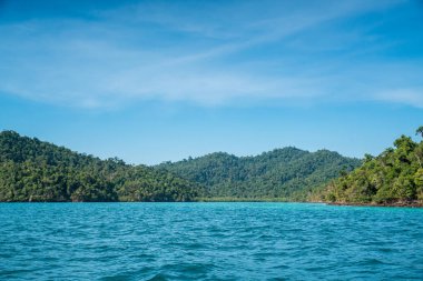 Adada sakin dalga deniz ve mavi gökyüzü geniş atış arka plan üzerinde tek başına