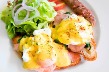 Somon füme, sosu, yeşil salata sebze ve ızgara sosis yumurta benedict