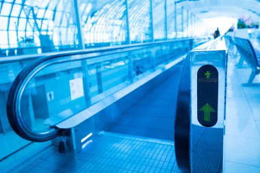 Seyahat kavramı. Yürüyen merdiven yürüyüş yolu modern Havaalanı terminal içinde. Mavi renklerde görüntü 