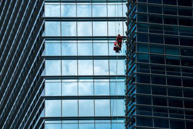 Yüksek binadaki pencereleri temizleyen bir grup işçi