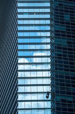 Yüksek binadaki pencereleri temizleyen bir grup işçi