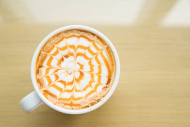 Sıcak macchiato kahve karamel ahşap masa üzerinde beyaz Kupası ile