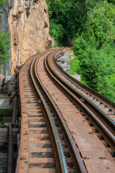 Old railroad tracks on bridge beside cliff rock — Stock Photo, Image