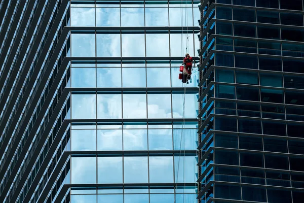 Yüksek binadaki pencereleri temizleyen bir grup işçi