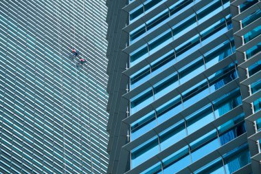 Yüksek binadaki pencereleri temizleyen bir grup işçi