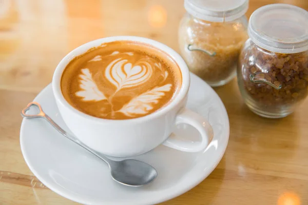 Café con leche caliente arte latte en mesa de madera — Foto de Stock