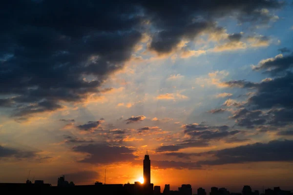 Edificio alto en el marco medio, el sol se pone detrás . — Foto de Stock