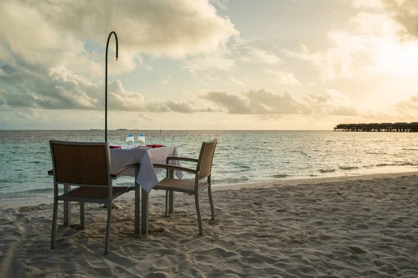 Table outdoor next to sea scenic prepare for special romantic dinner time.