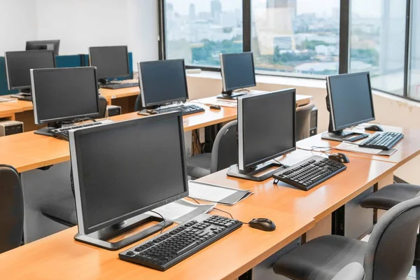 Sala de informática vazia ordenadamente colocada para o estudante . Fotos De Bancos De Imagens