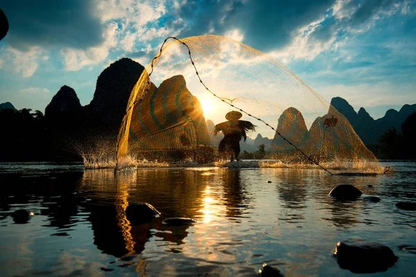 Silhueta de pescador Cormorão usando rede no antigo bambo Fotos De Bancos De Imagens Sem Royalties