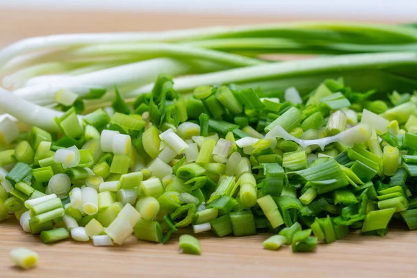 Alho verde picado em tábua de corte preparada para cozinhar . — Fotografia de Stock