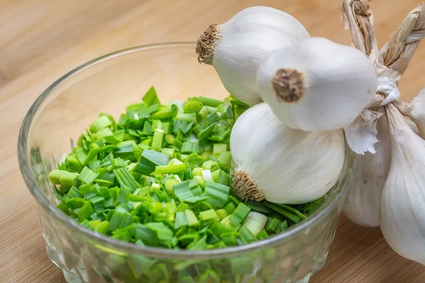 Alho verde picado em tábua de corte preparada para cozinhar . — Fotografia de Stock