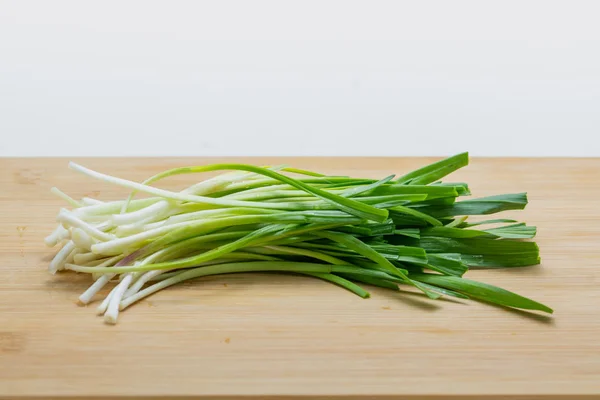 Raw green garlic on cutting board preparated for cooking. Stock Photo