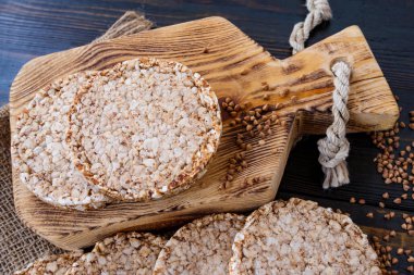 Ahşap arka plan zekâ üzerinde havadar karabuğday yuvarlak diyet somun