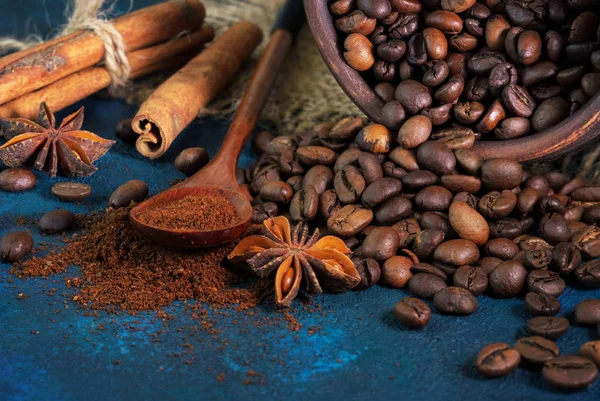Granos de café esparcidos sobre un fondo textural azul, anís sta —  Fotos de Stock