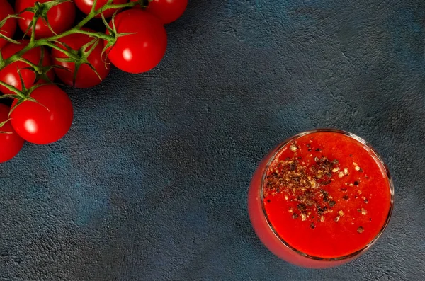 Glasbecher mit Tomatensaft mit gemahlenem schwarzen Pfeffer und Kirsche — Stockfoto
