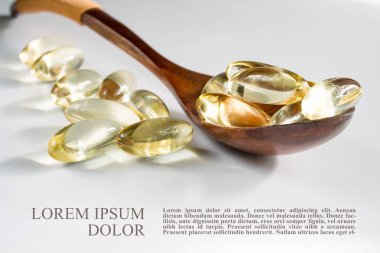 Bir ilaç Omega-3 ile sarı jelatin kapsüller, tahta bir kaşık,