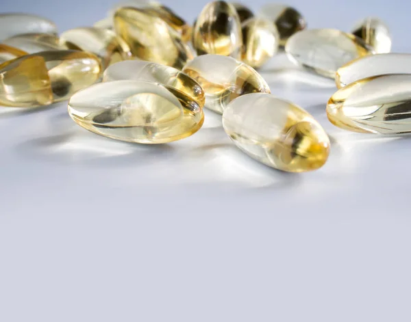 Yellow gelatin capsules with a  drug Omega-3  on a grey backgro — Stock Photo, Image