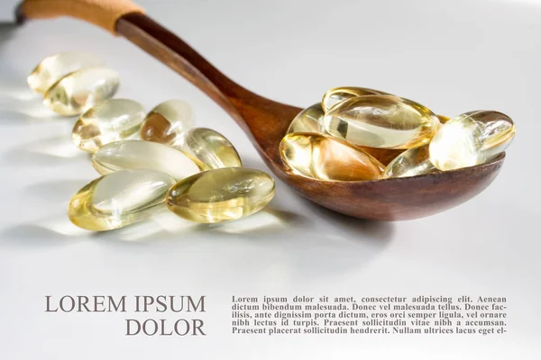 Yellow gelatin capsules with a  drug Omega-3, in a wooden spoon, — Stock Photo, Image
